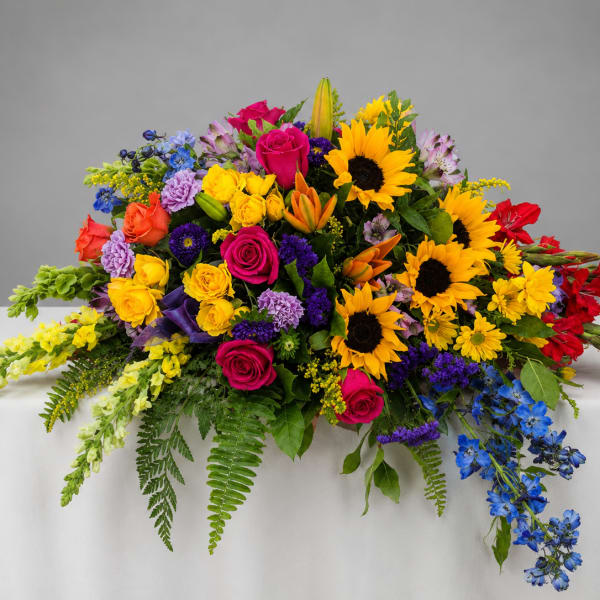 Colorful mixed flower arrangement with sunflowers, roses, and lilies on a table