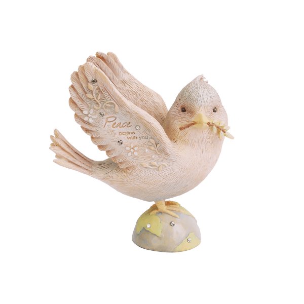 Cream-colored dove figurine with raised wings on a small globe base, holding a branch in its beak.