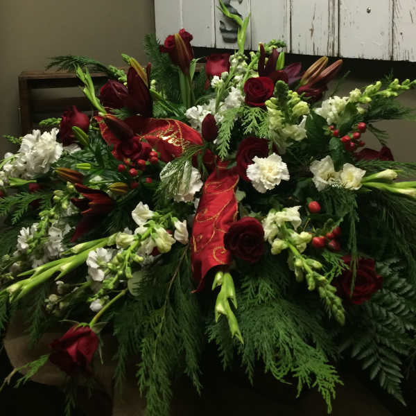 Red roses and white flowers arranged with a red ribbon