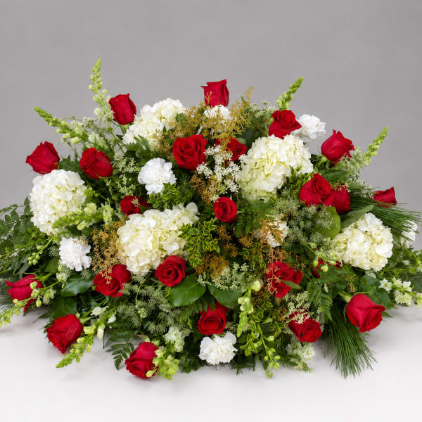 Red roses and white hydrangeas arranged in a low, wide spray