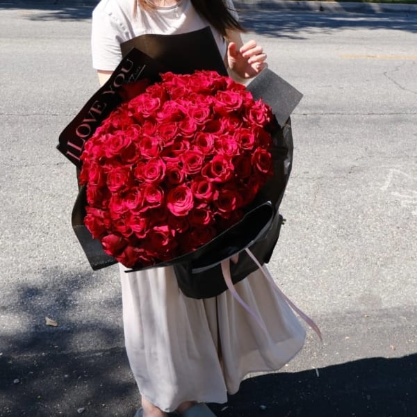 Large bouquet of red roses wrapped in black paper
