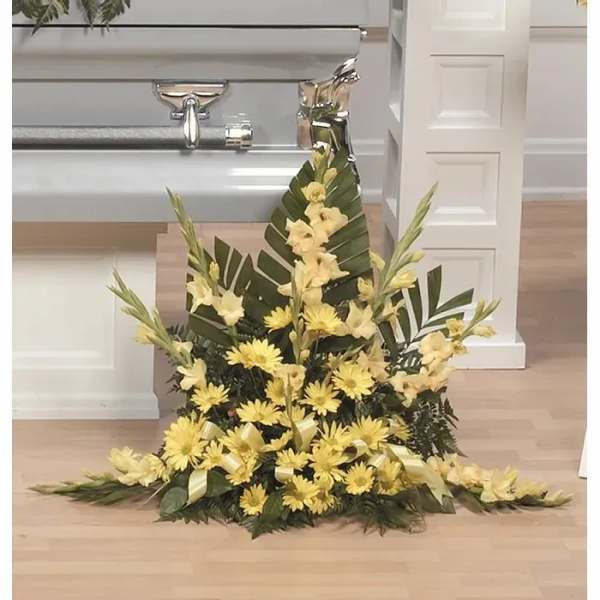 Tall yellow floral spray with palm leaves and ribbon accents