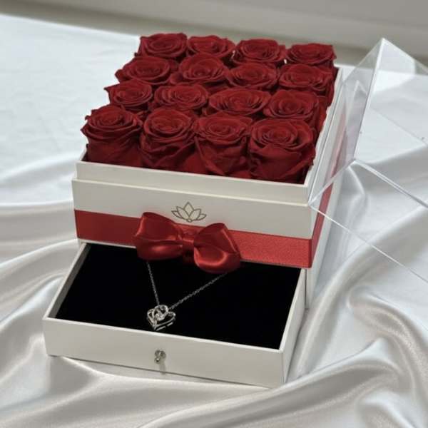 Box of red roses with a necklace in a drawer below