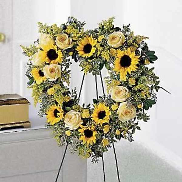 Sunflower and cream rose wreath on a black easel
