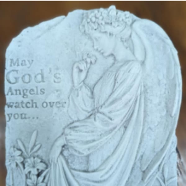 White memorial plaque with an angel and flowers