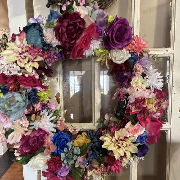 Colorful floral wreath made of assorted blooms on a window frame