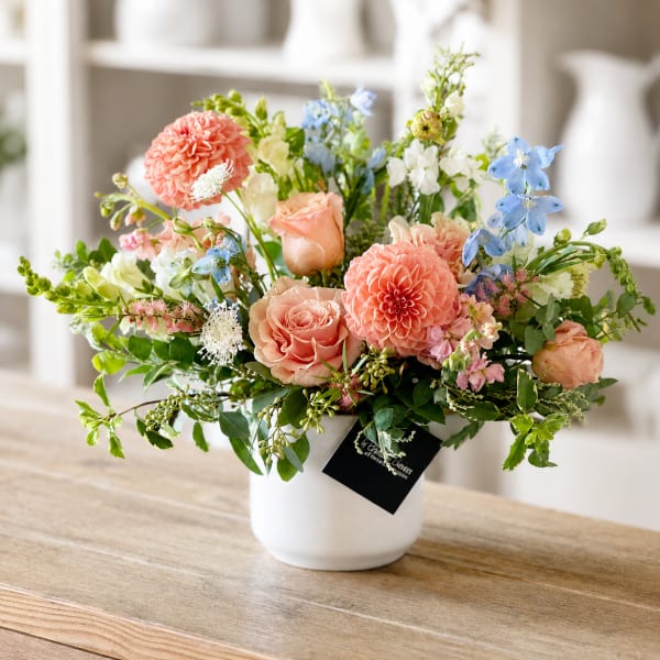 Mixed pastel flower arrangement in a white vase