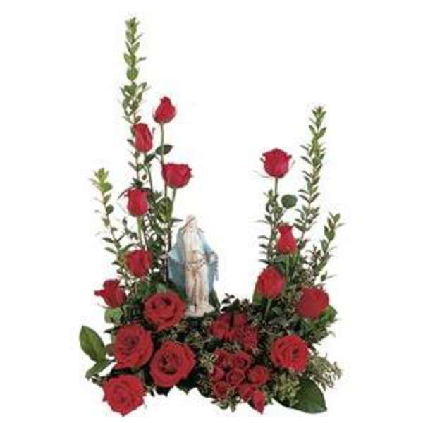 Red roses arranged around a small religious statue