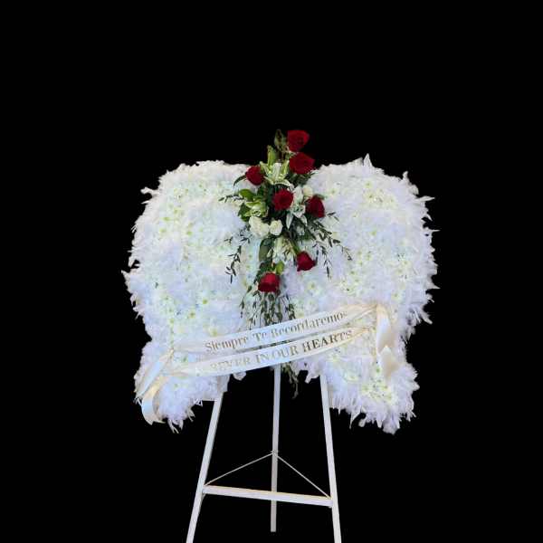 White funeral wreath with red roses on a standing easel