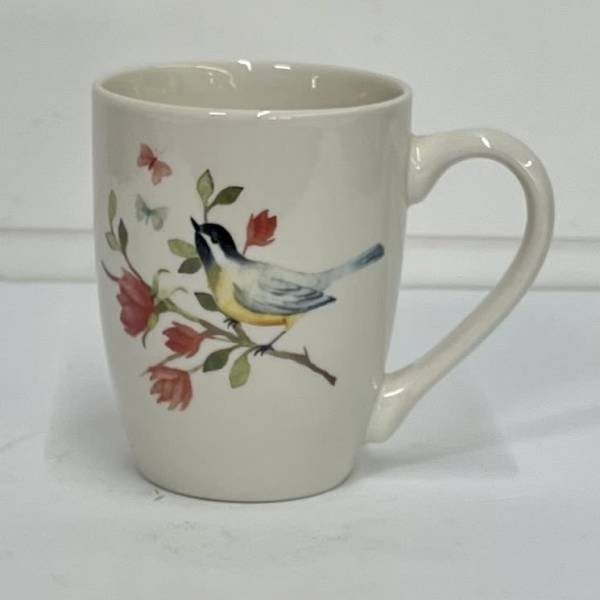 Cream ceramic mug with a bird and floral branch design