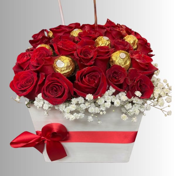 Red roses with gold-wrapped chocolates in a white box with a red ribbon