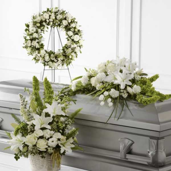 White floral funeral casket spray, wreath, and basket arrangement