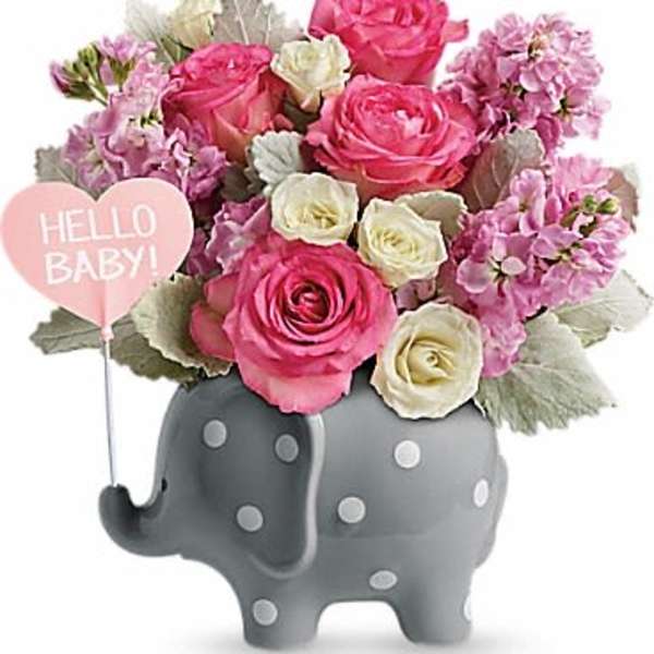 Pink and white roses in a gray elephant planter with a "Hello Baby!" sign