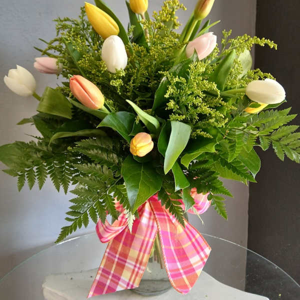 Mixed tulip bouquet in a glass vase with a pink plaid ribbon