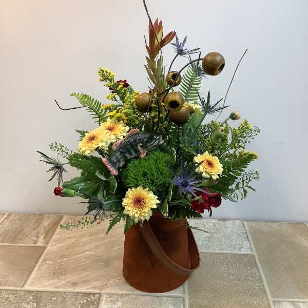 Mixed floral arrangement in a brown container with a fish decoration