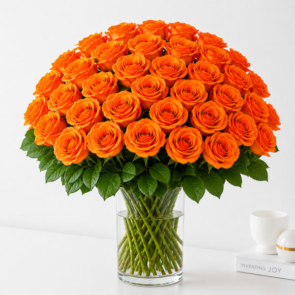 Orange roses arranged in a clear glass vase.