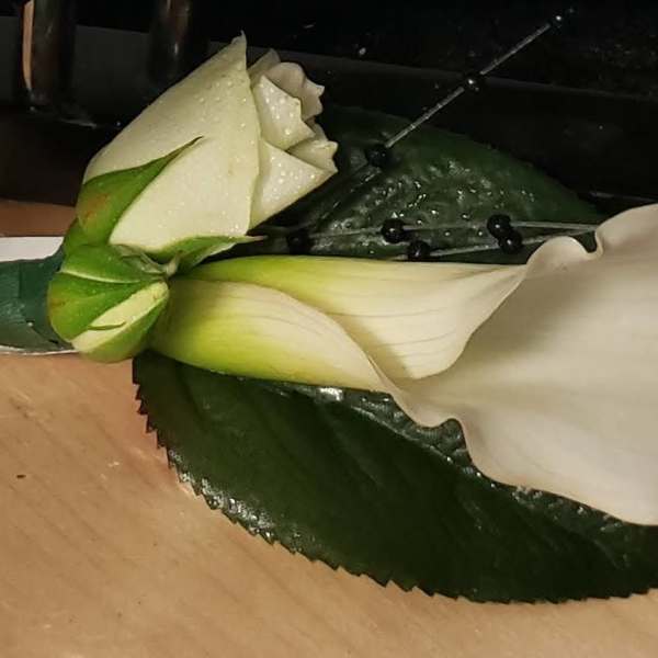 White calla lily boutonniere with a dark green leaf