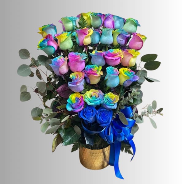 Bouquet of rainbow-colored roses in a gold vase with a blue ribbon