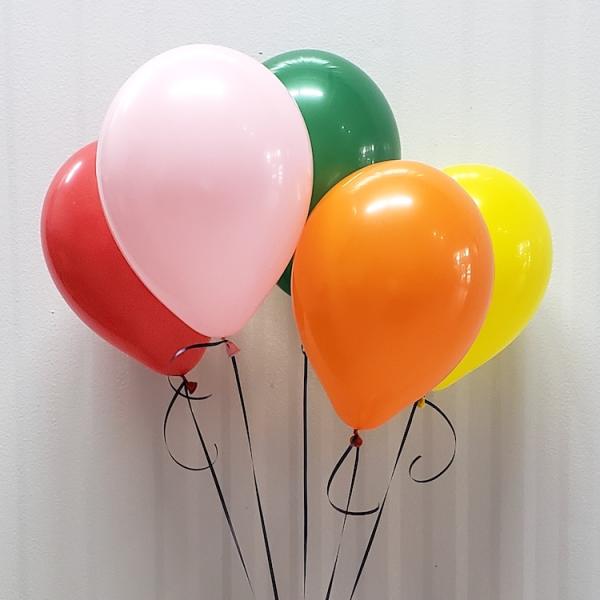 Cluster of colorful balloons against a plain wall