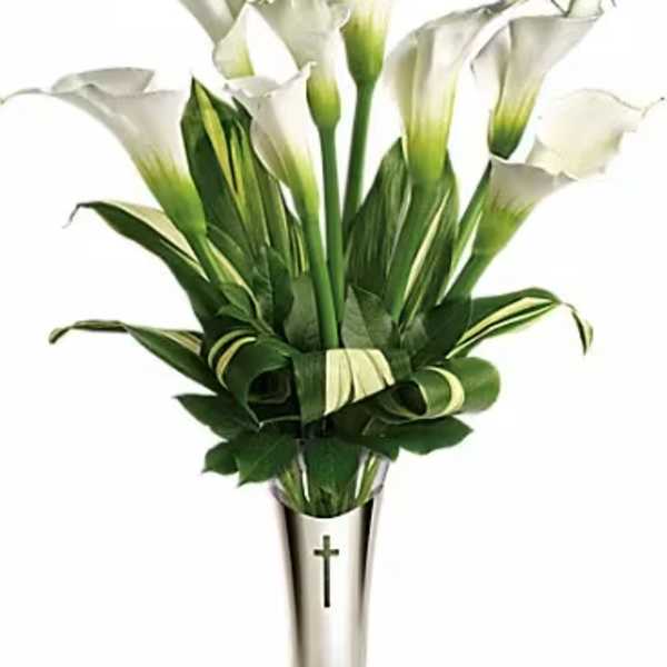 White calla lilies in a silver vase with a cross