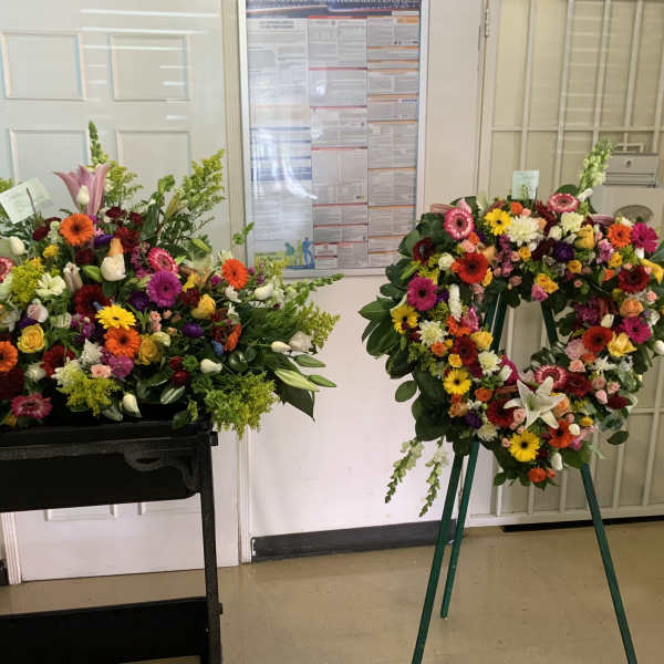 Colorful floral casket spray and standing wreath with mixed blooms