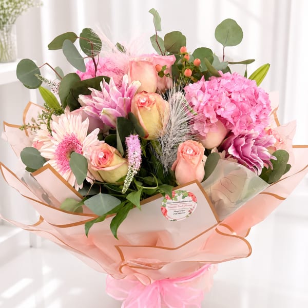 Pink and peach bouquet with roses, hydrangea, and gerbera daisies