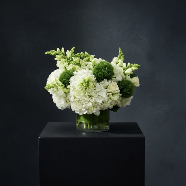 White and green floral arrangement in a glass vase