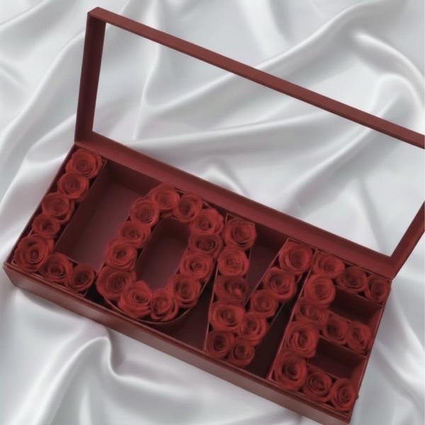 Red roses arranged in a gift box spelling "LOVE"