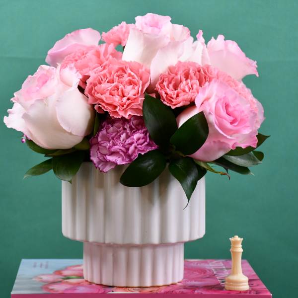 Pink roses and carnations in a white ribbed vase