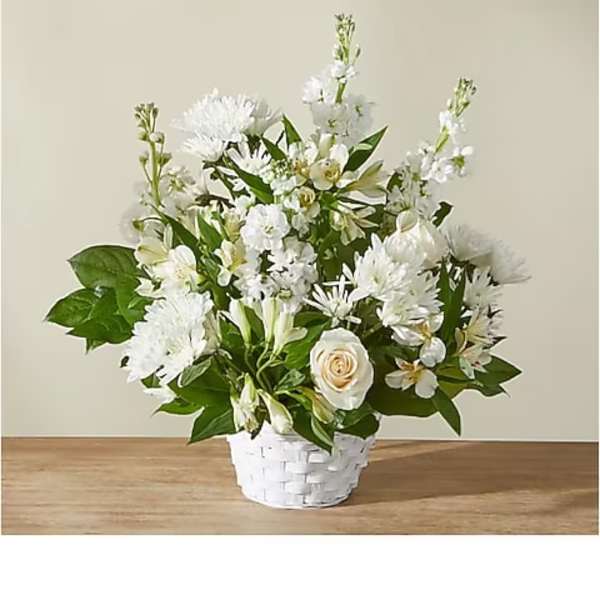White floral arrangement in a white basket vase