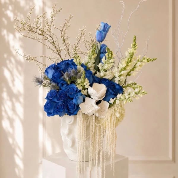 Blue and white floral arrangement in a white vase