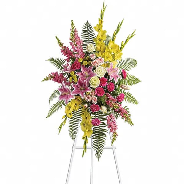 Tall standing floral spray with pink, yellow, and white flowers on a metal easel