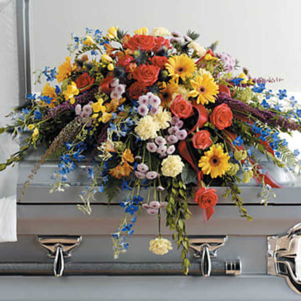 Colorful casket spray with roses, daisies, and mixed blooms