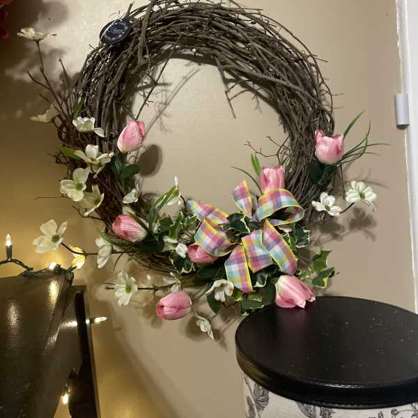 Floral wreath with pink tulips, white blossoms, and a plaid ribbon