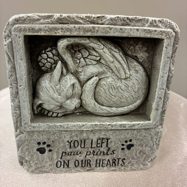 Stone memorial with a sleeping cat relief and paw prints