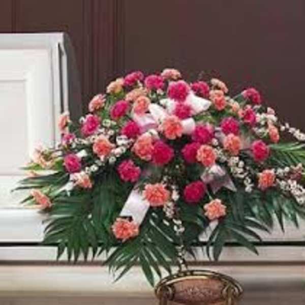 Pink and peach floral casket spray with white ribbon accents