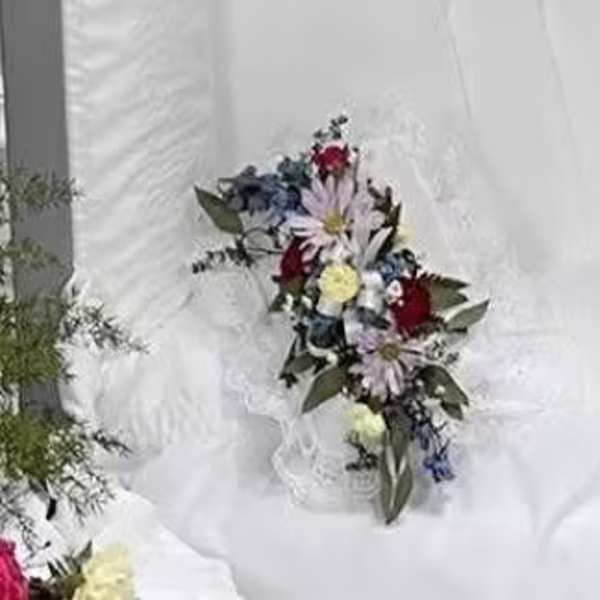 White floral bouquet with red and blue accents on white fabric