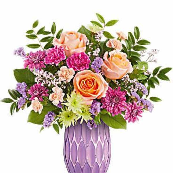 Bouquet of peach and pink roses in a purple vase