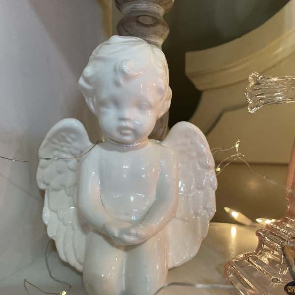 White ceramic angel figurine with wings and folded hands