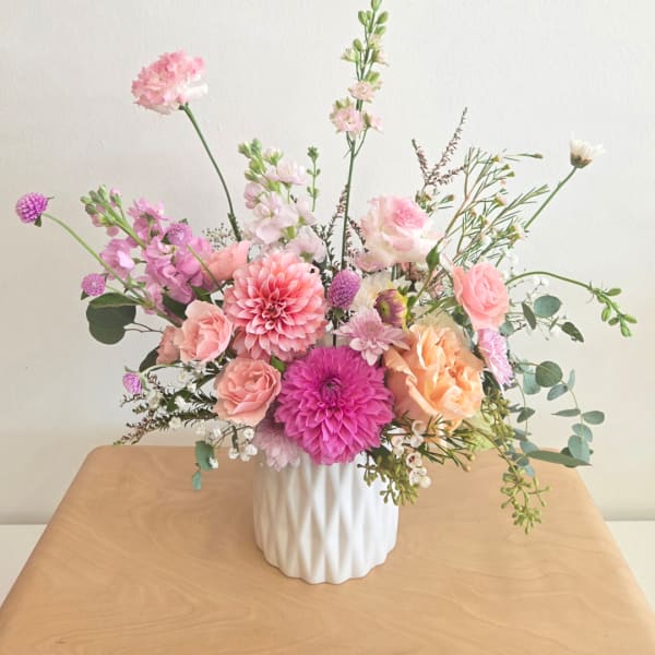 Pink and peach mixed flower arrangement in a white vase