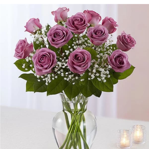 Pink roses arranged in a clear glass vase with baby's breath