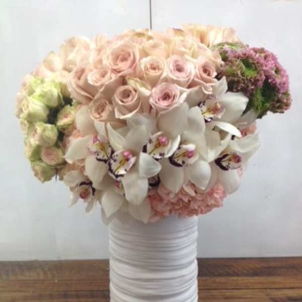 Bouquet of pale pink roses and white orchids in a white vase
