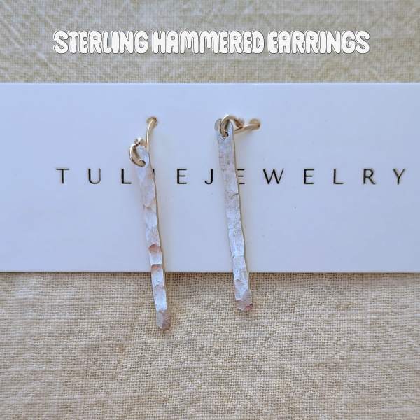 Pair of hammered silver drop earrings on a jewelry card