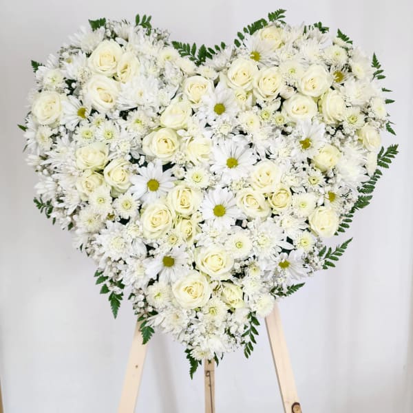 Heart-shaped arrangement of white roses and daisies on a stand