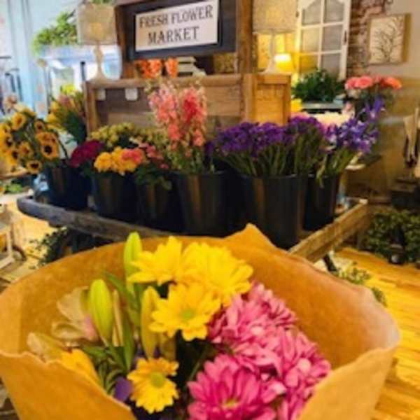 Bouquet of pink and yellow daisies with lilies in brown paper