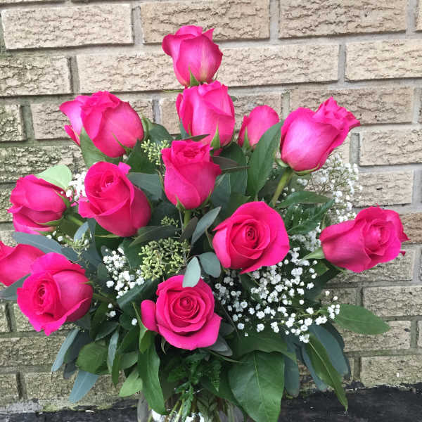 Bouquet of bright pink roses in a clear glass vase