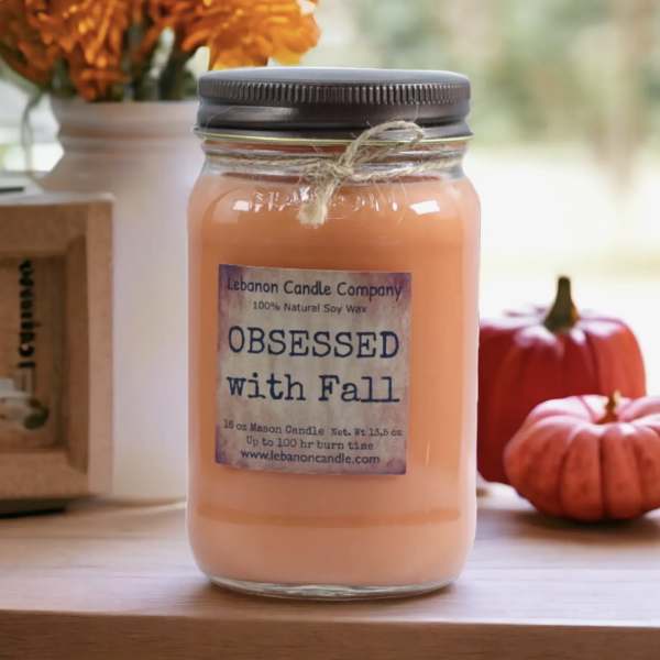 Orange candle in a mason jar with a fall label and twine tie