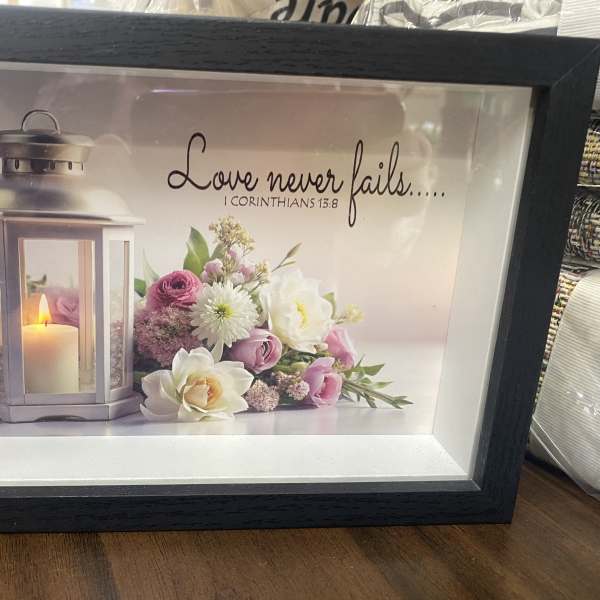Framed candle and pink-white floral print with a Bible verse