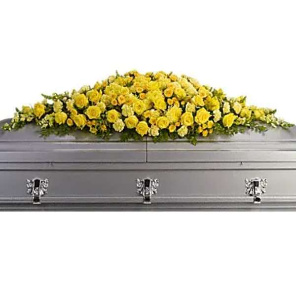 Yellow floral casket spray on a gray casket