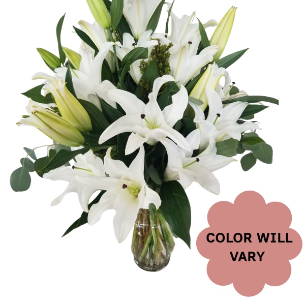 White lilies arranged in a clear glass vase